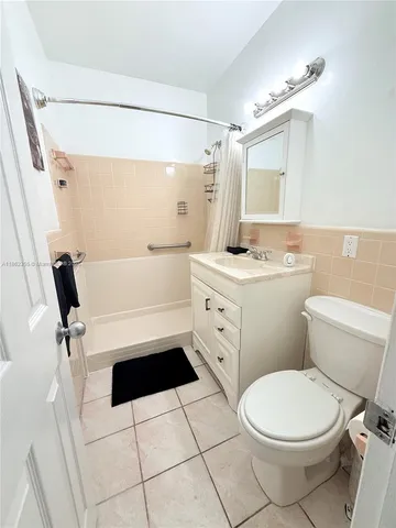 a bathroom with a sink a toilet a mirror and shower