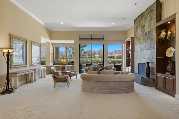 a living room with fireplace furniture and a large window