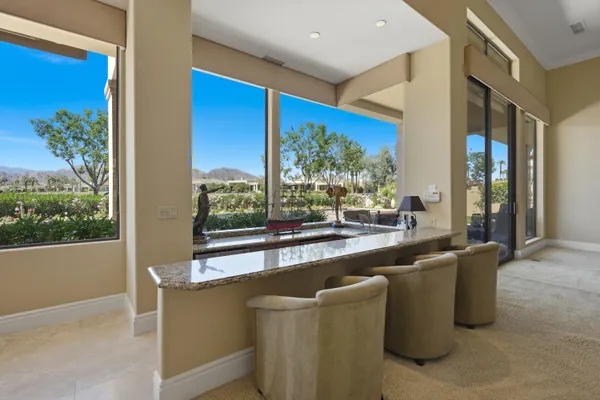 a living room with stainless steel appliances granite countertop furniture and a large window