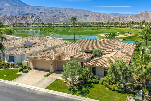 an aerial view of a house with a garden and lake view