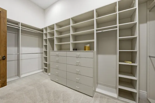 a spacious bedroom with a bed and wooden floor