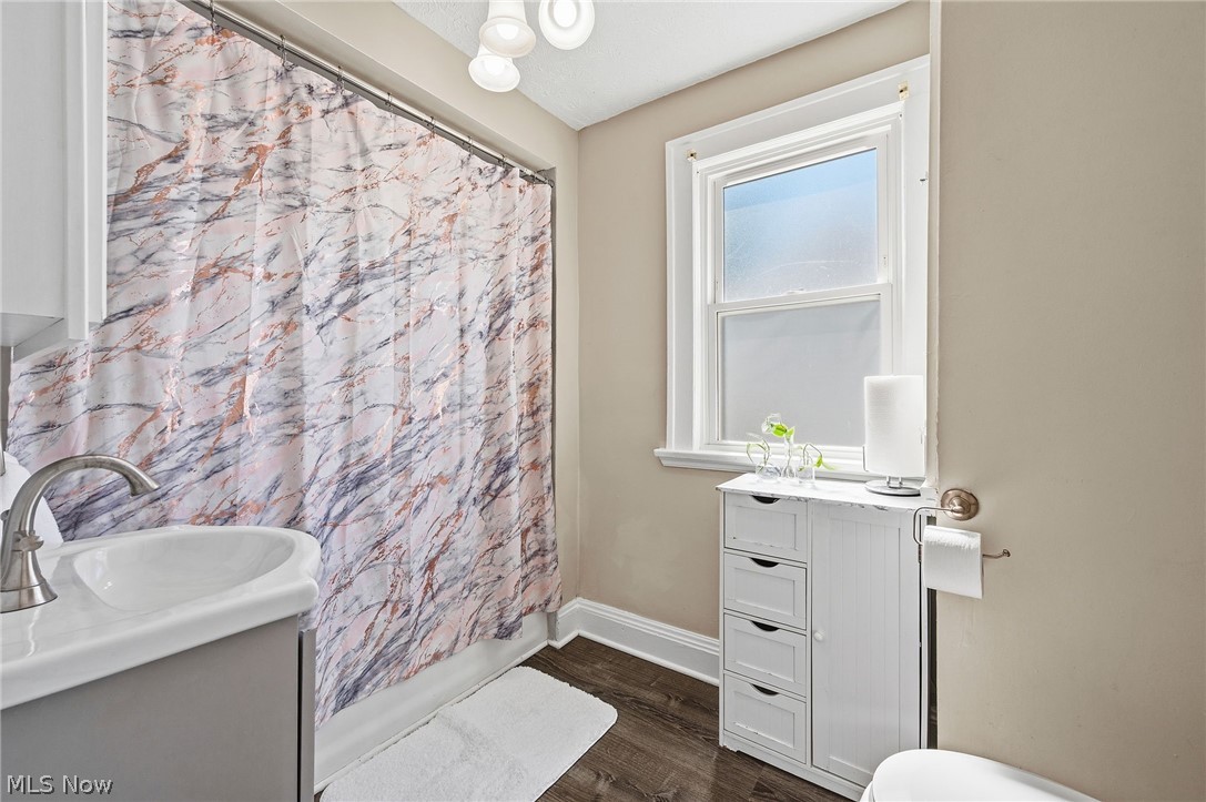 3386 Sylvanhurst Road Cleveland Heights, OH 44112 - Photo 27 of 46 Bathroom featuring a single pane window, dark wood-finish flooring, and a vanity with a rectangular sink and stainless steel faucet