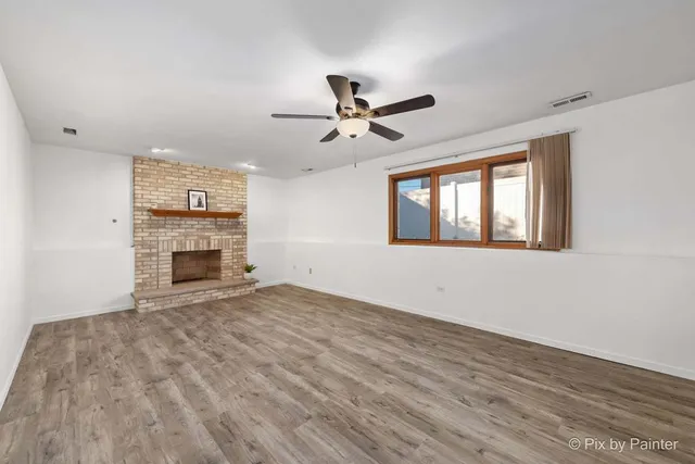 a view of empty room with a fireplace and window