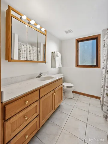 a spacious bathroom with a double vanity sink a mirror and a toilet