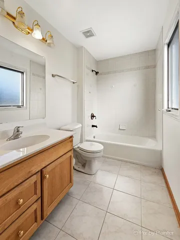 a spacious bathroom with a granite countertop sink a toilet mirror and a bathtub