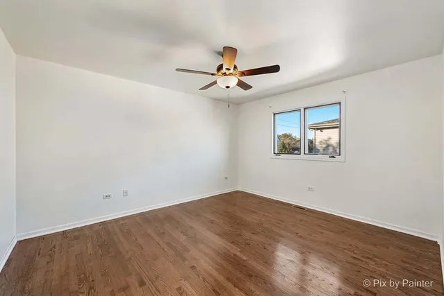a view of a big room with wooden floor and a ceiling fan