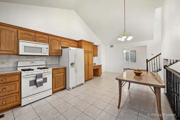 a kitchen with stainless steel appliances kitchen island granite countertop a stove a sink dishwasher and a refrigerator with cabinets