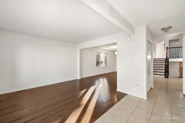 a view of a hallway with wooden floor and stairs