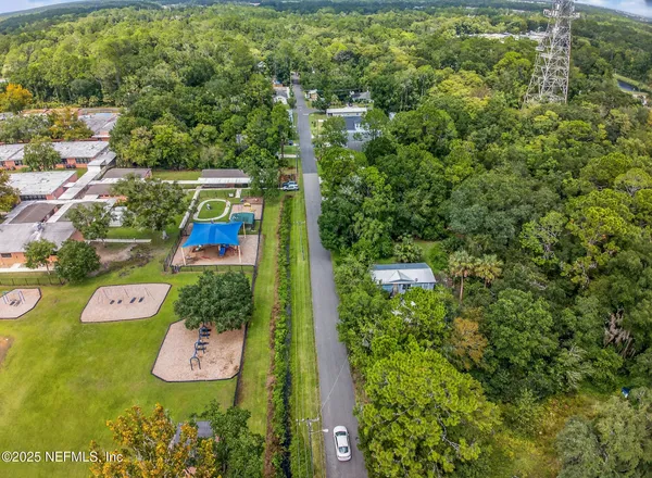 an aerial view of residential house with outdoor space and trees all around