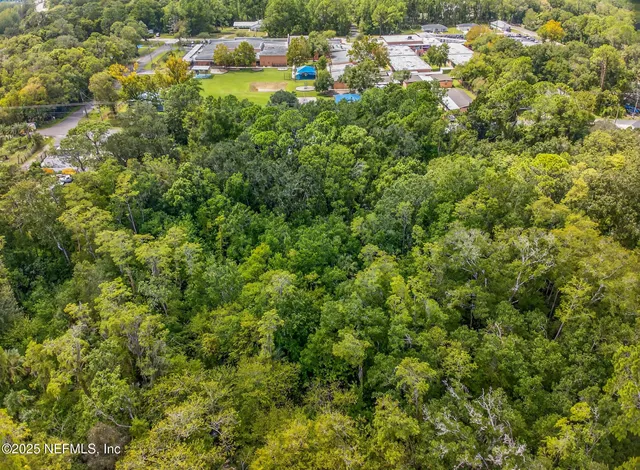 a view of a house with a lush green forest