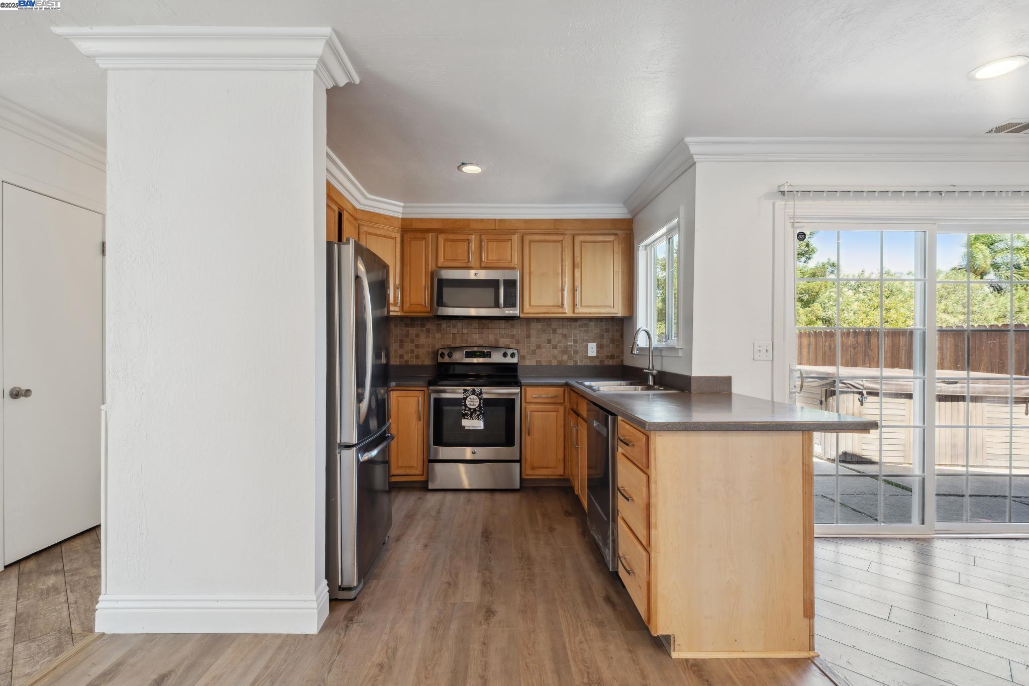148 Spinnaker Pittsburg, CA 94565 - Photo 5 of 24 a kitchen with granite countertop a stove top oven a sink a counter space and cabinets