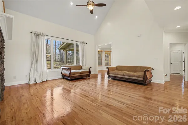 a large kitchen with stainless steel appliances granite countertop a stove and a wooden floors