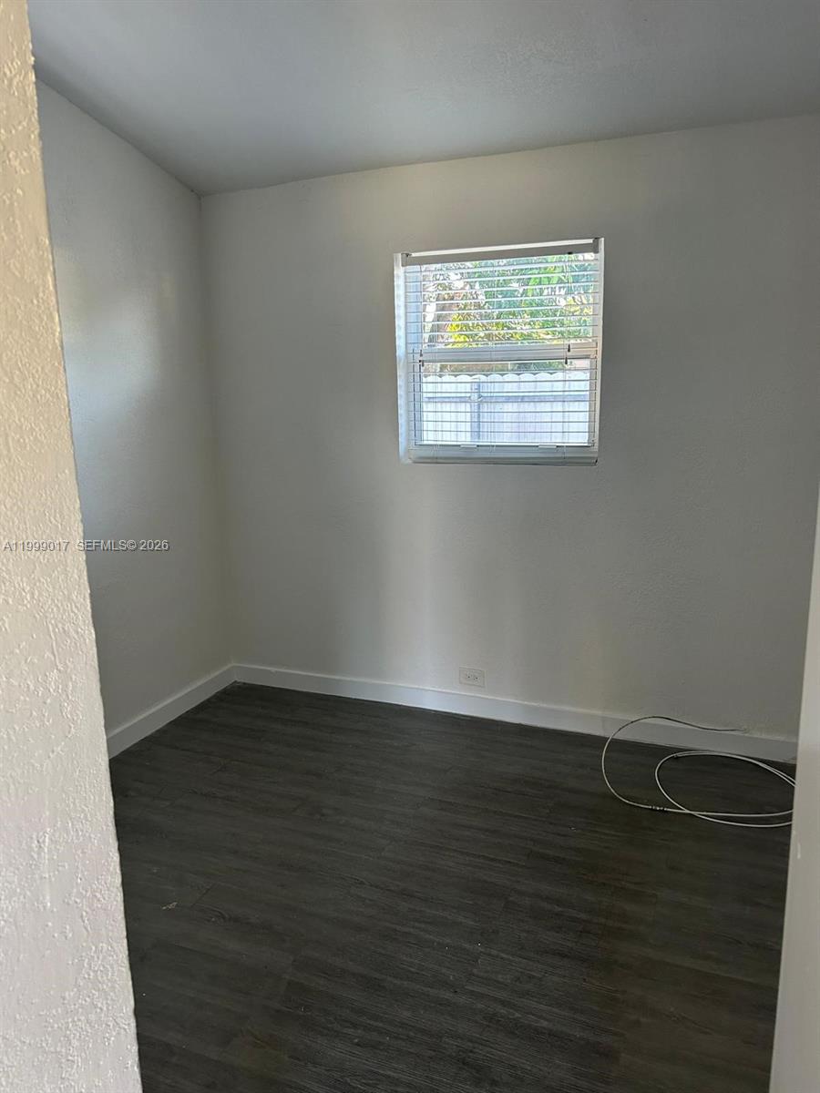 10296 Southwest 175th Street, Unit 10296 Miami, FL 33157 - Photo 3 of 9 an empty room with wooden floor and windows