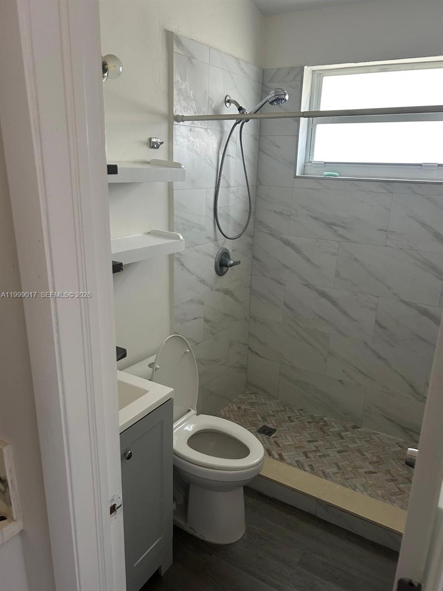 10296 Southwest 175th Street, Unit 10296 Miami, FL 33157 - Photo 5 of 9 a bathroom with a granite countertop toilet a sink and shower