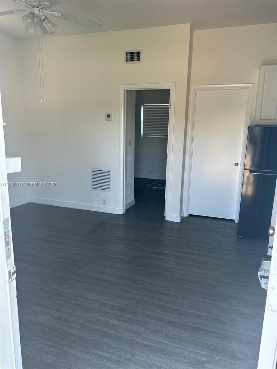 10296 Southwest 175th Street, Unit 10296 Miami, FL 33157 - Photo 6 of 9 a view of an empty room with wooden floor and a window