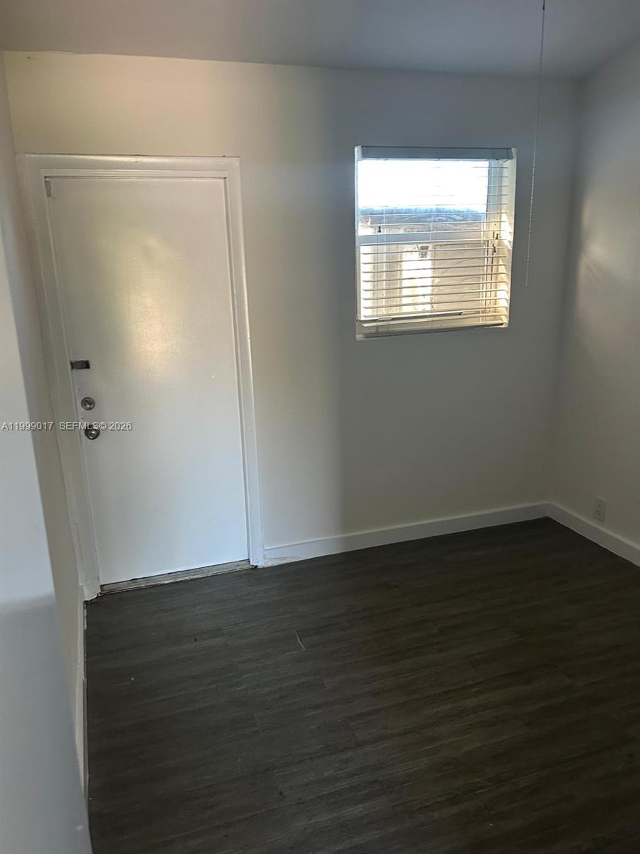 10296 Southwest 175th Street, Unit 10296 Miami, FL 33157 - Photo 7 of 9 an empty room with wooden floor and windows