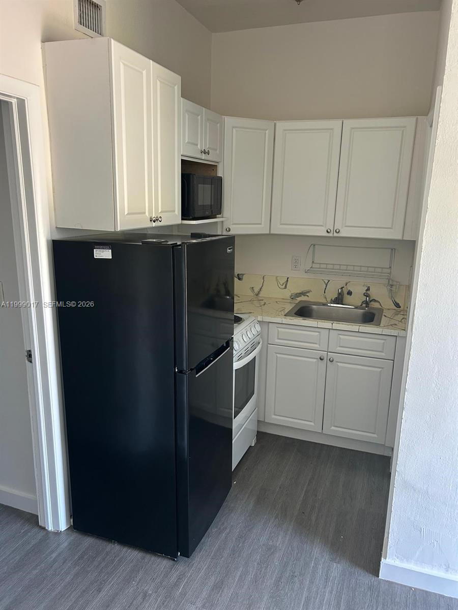 10296 Southwest 175th Street, Unit 10296 Miami, FL 33157 - Photo 9 of 9 a kitchen with a sink a microwave a refrigerator and cabinets