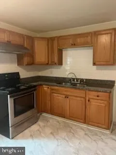 a kitchen with granite countertop cabinets stainless steel appliances and a counter space