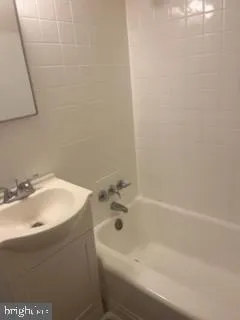a bathroom with a white bath tub and a sink