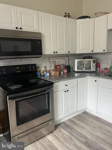 a kitchen with stainless steel appliances a stove a microwave and cabinets