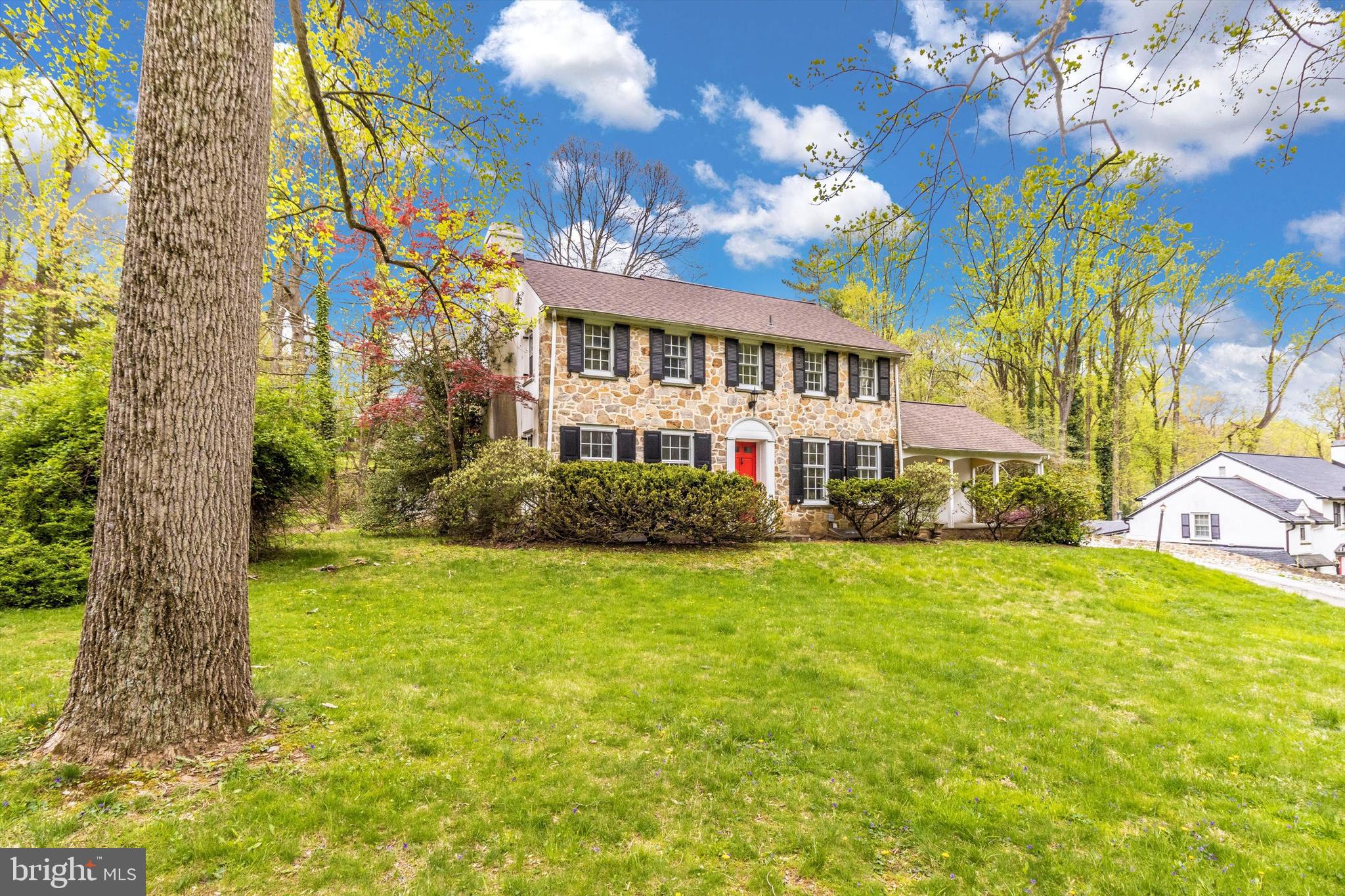 a front view of a house with a big yard and potted plants
