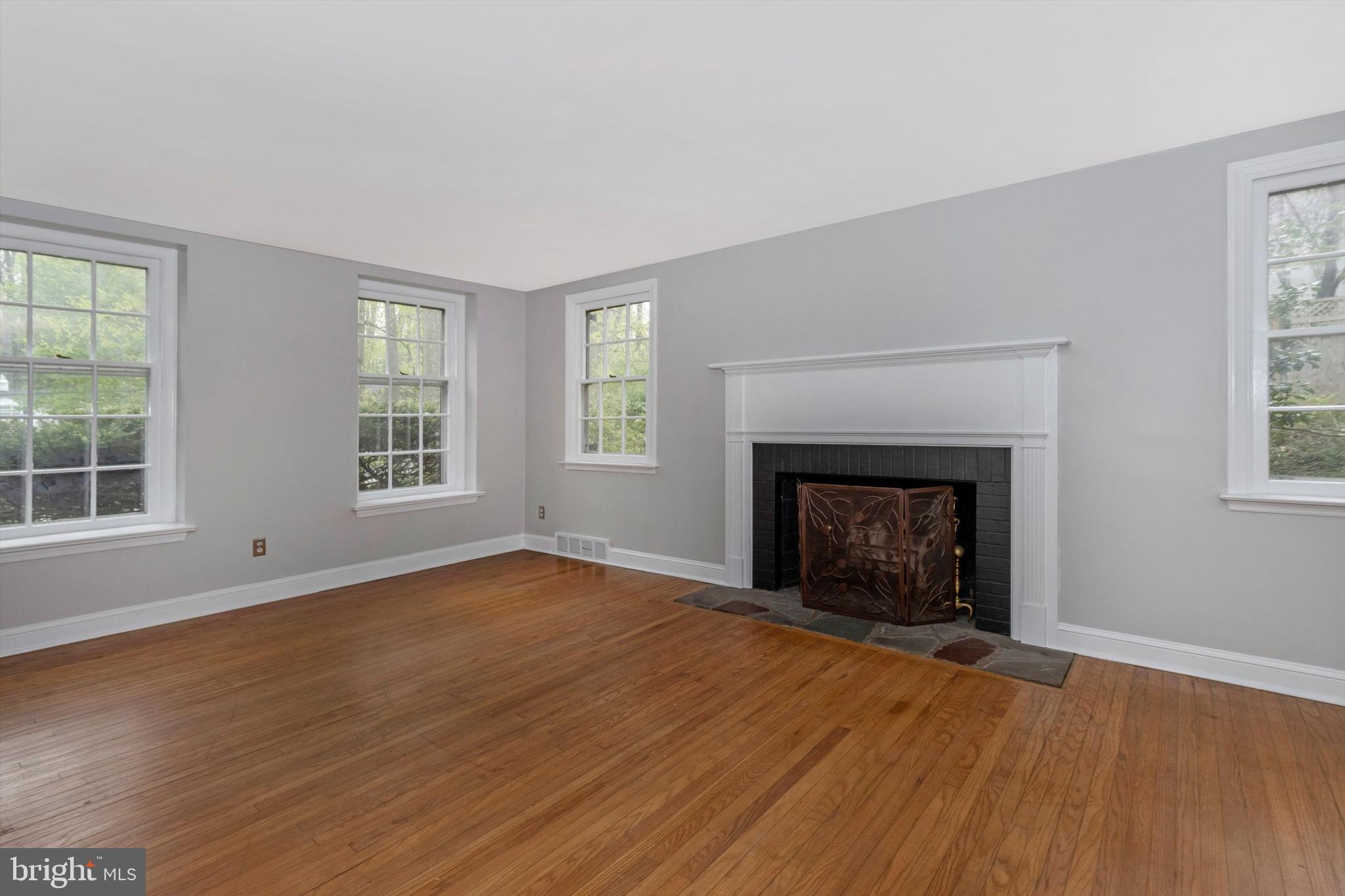 414 Devon State Road Devon, PA 19333 - Photo 6 of 31 an empty room with wooden floor fireplace and windows