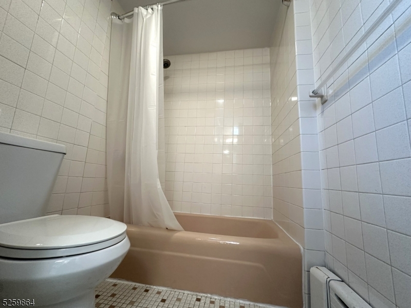 89 Getty Avenue, Unit 3 Clifton, NJ 07011 - Photo 3 of 28 a white toilet sitting next to a bath tub