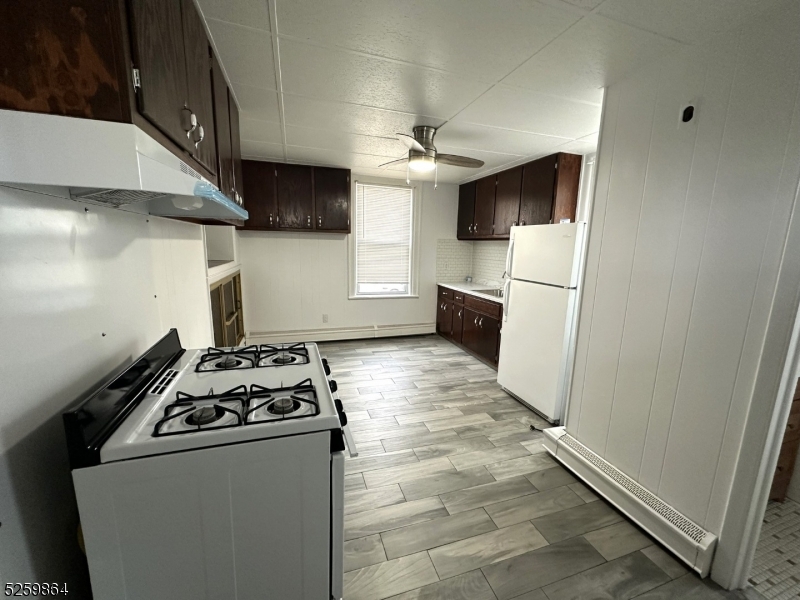 89 Getty Avenue, Unit 3 Clifton, NJ 07011 - Photo 5 of 28 a kitchen with stainless steel appliances a refrigerator a stove a microwave and a sink