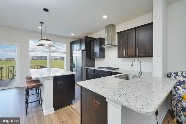 a kitchen with granite countertop a sink a counter space appliances and cabinets