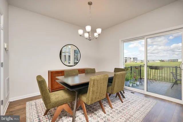 a view of a dining room with furniture a chandelier and wooden floor