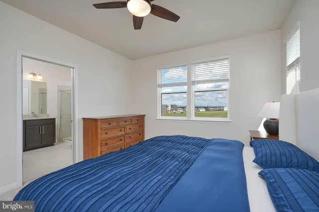 a bedroom with a bed and a dresser with wooden floor