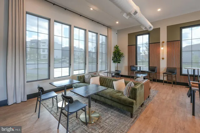 a living room with furniture and floor to ceiling windows