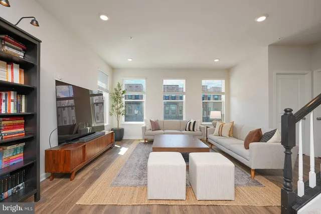 a living room with furniture a flat screen tv and a book shelf