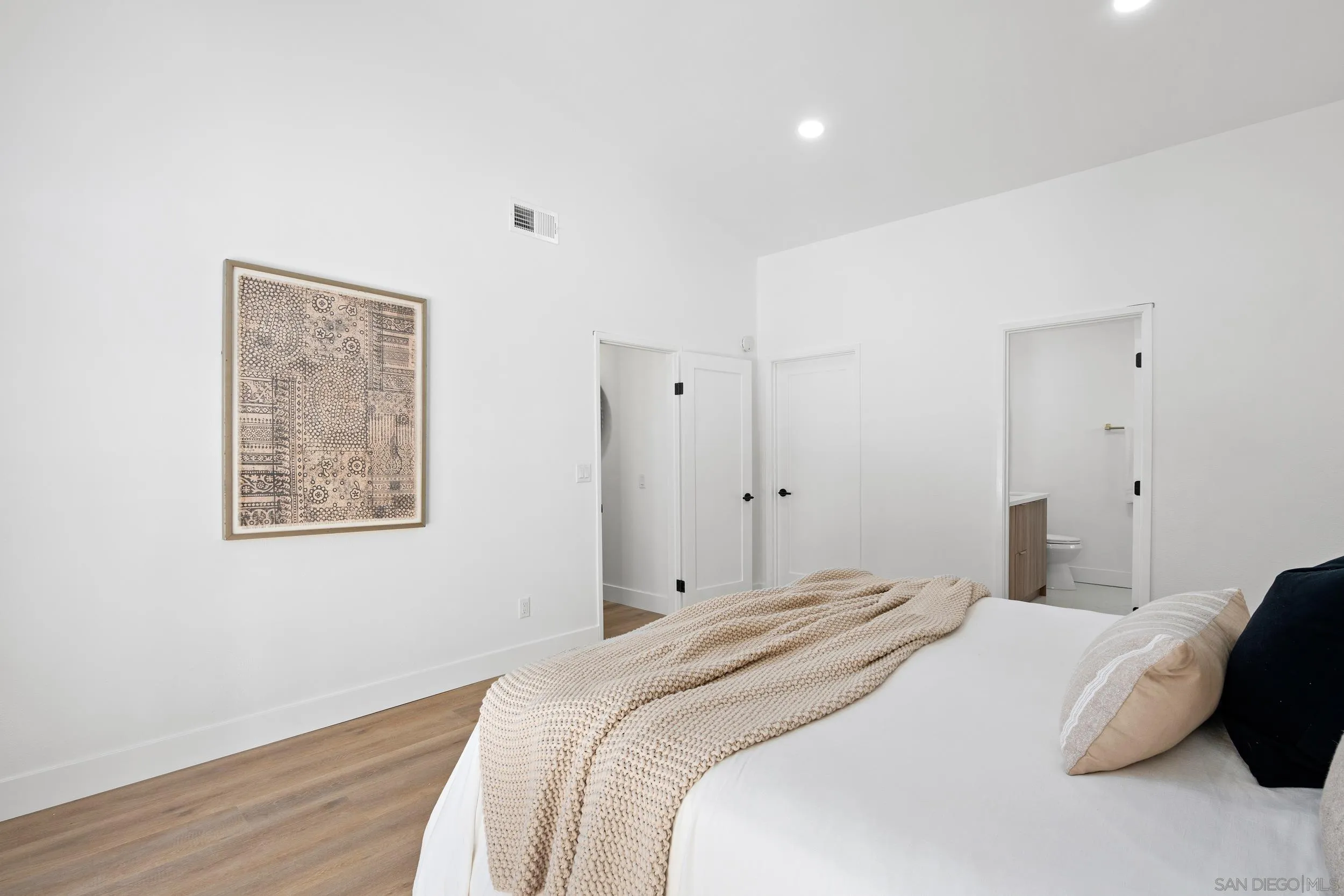 1621 Downs Street Oceanside, CA 92054 - Photo 26 of 38 a bedroom with a bed and a wall painting