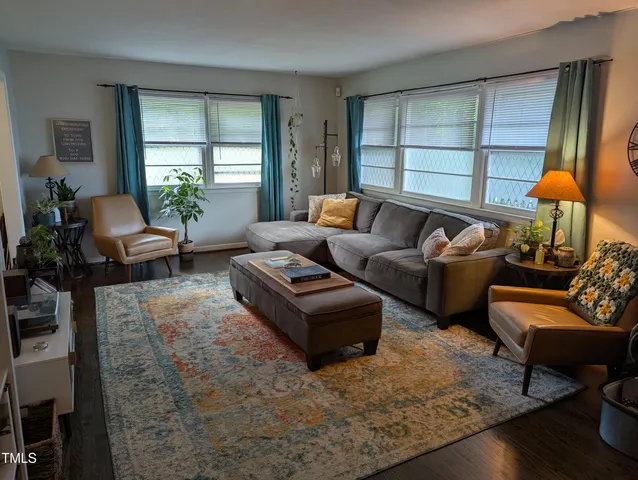 a living room with furniture a rug and a book shelf