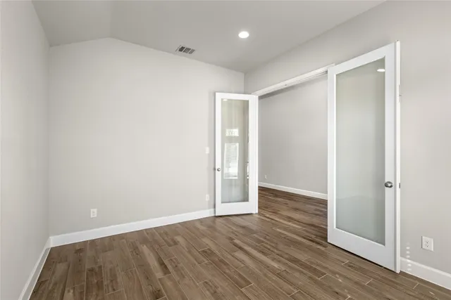 an empty room with wooden floor and door