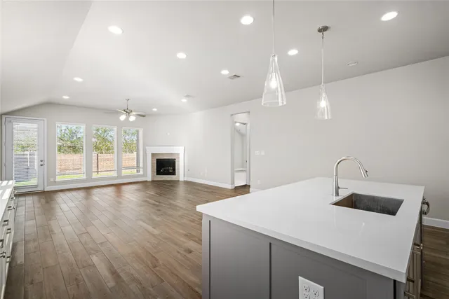 a kitchen with a sink a fireplace and wooden floor