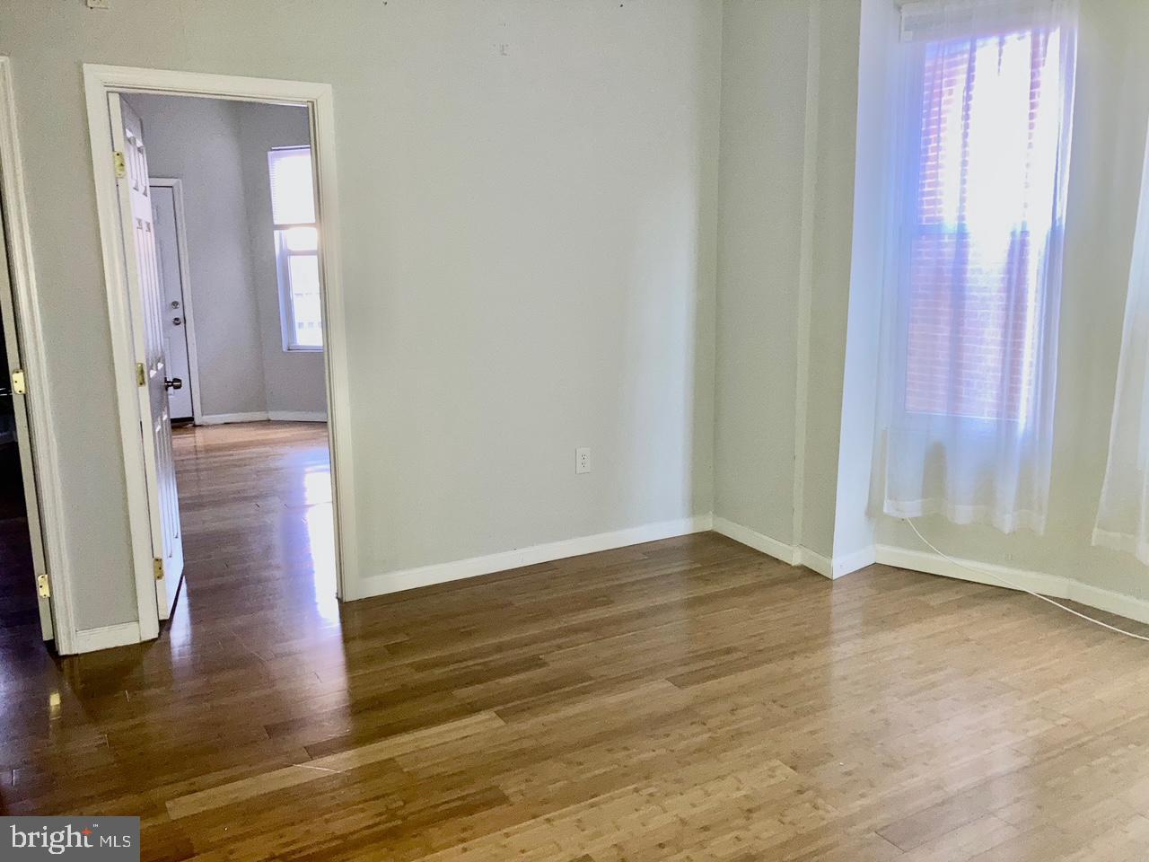 4825 Baltimore Avenue, Unit 4 Philadelphia, PA 19143 - Photo 3 of 10 a view of an empty room with wooden floor and a window
