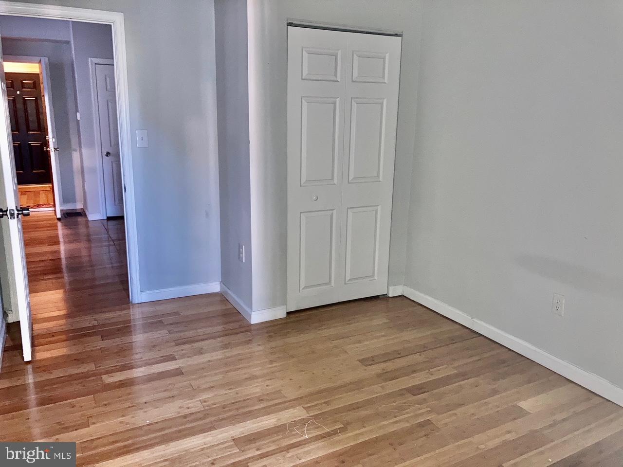 4825 Baltimore Avenue, Unit 4 Philadelphia, PA 19143 - Photo 4 of 10 a view of an empty room with wooden floor and a window