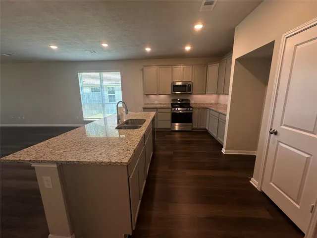 a kitchen with counter top space and wooden floor