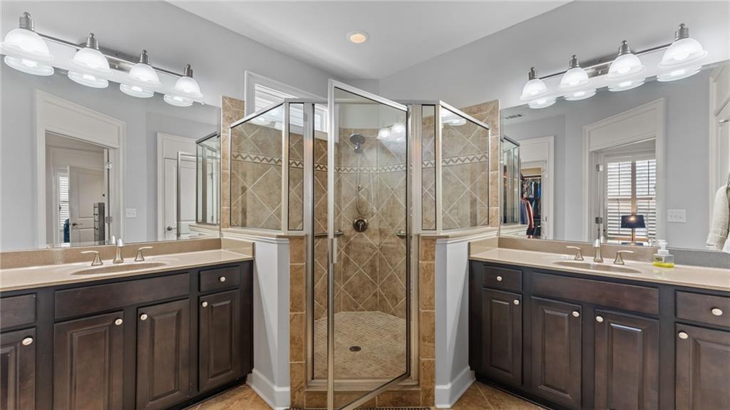 3418 Locust Cove Road Gainesville, GA 30504 - Photo 16 of 61 a bathroom with a double vanity sink mirror and shower