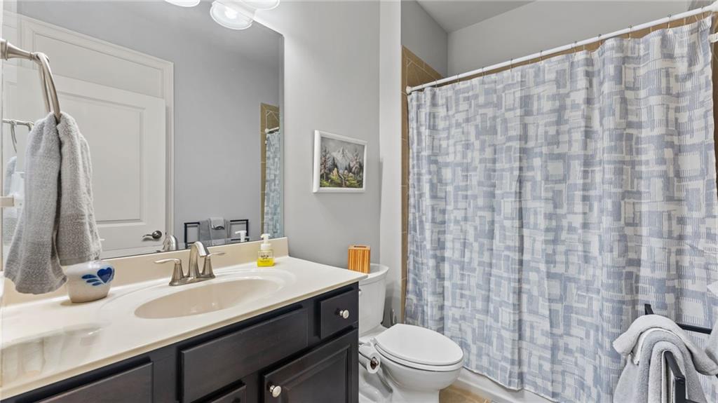 3418 Locust Cove Road Gainesville, GA 30504 - Photo 18 of 61 a bathroom with a sink a toilet and shower curtain