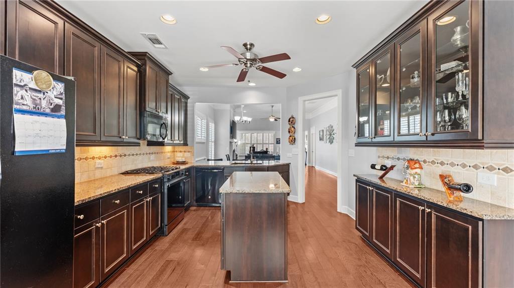 3418 Locust Cove Road Gainesville, GA 30504 - Photo 5 of 61 a kitchen with stainless steel appliances granite countertop a stove a sink dishwasher and wooden cabinets with wooden floor