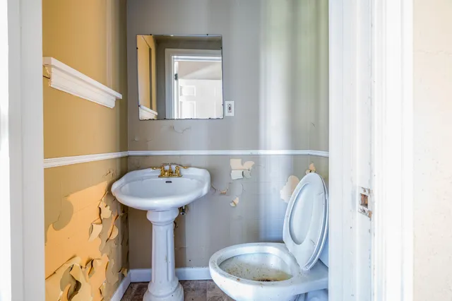 a bathroom with a sink a toilet and a mirror