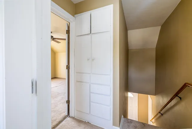 a view of a hallway with a ceiling fan
