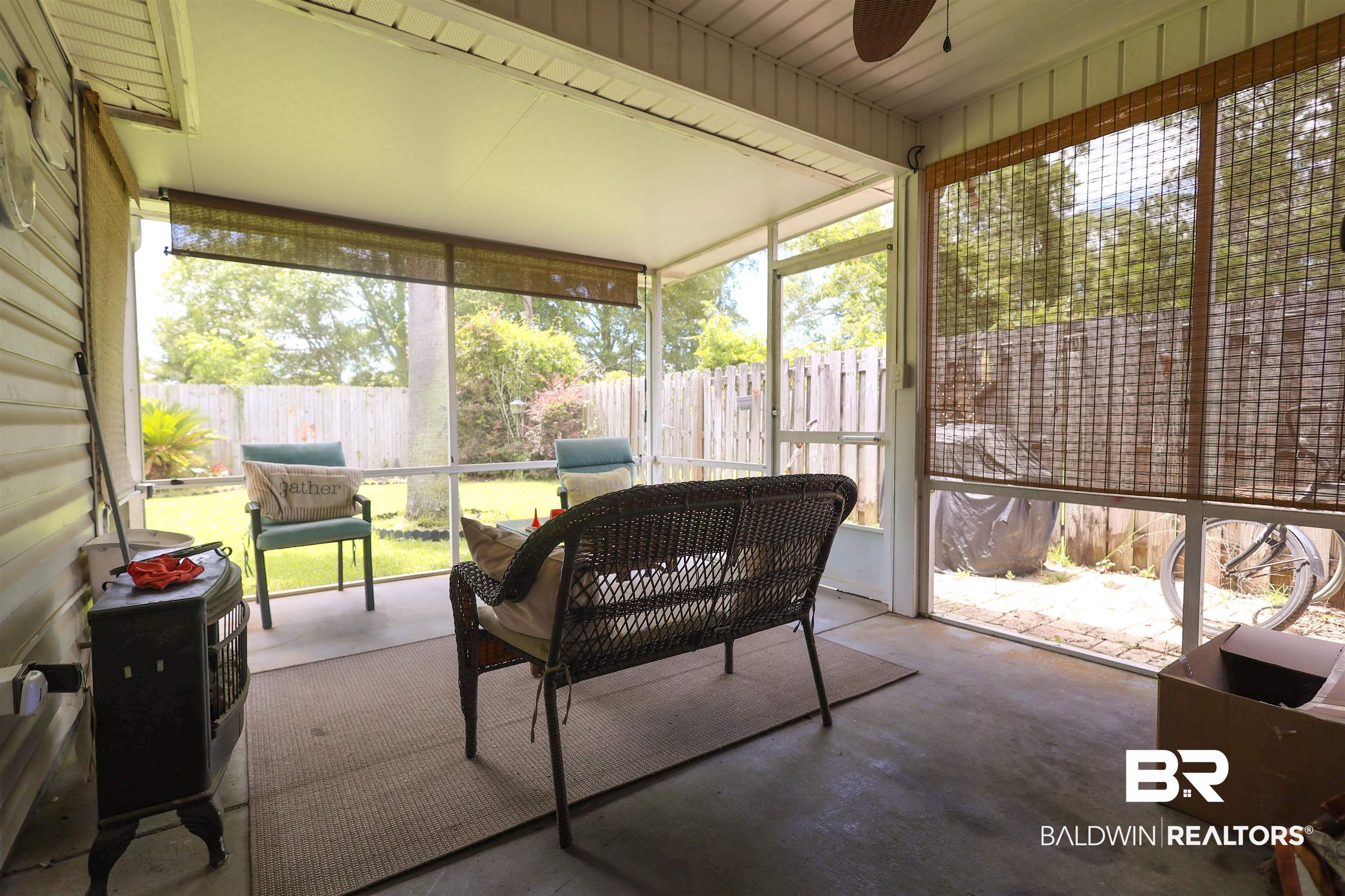 7790 Audubon Drive Foley, AL 36535 - Photo 33 of 39 Screened porch featuring a concrete slab, exterior siding, ceiling fan, and bamboo blinds