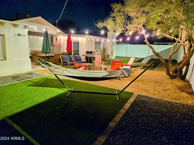 a view of a house with backyard water fountain and sitting area