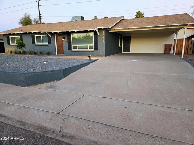a living room with furniture a flat screen tv and kitchen view