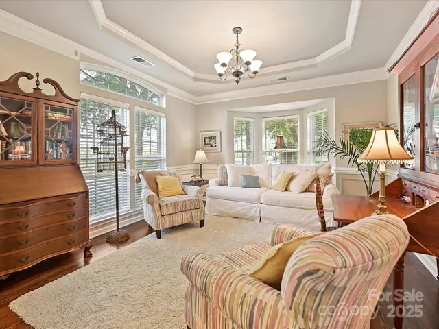a living room with furniture and a chandelier