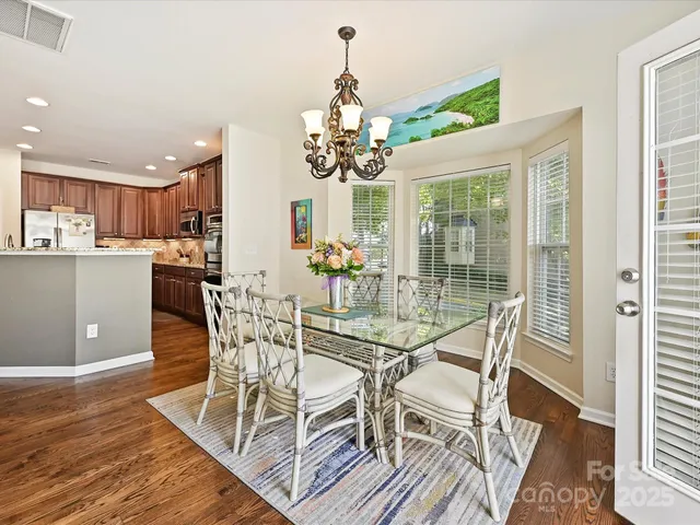 a view of a dining room with furniture wooden floor and chandelier